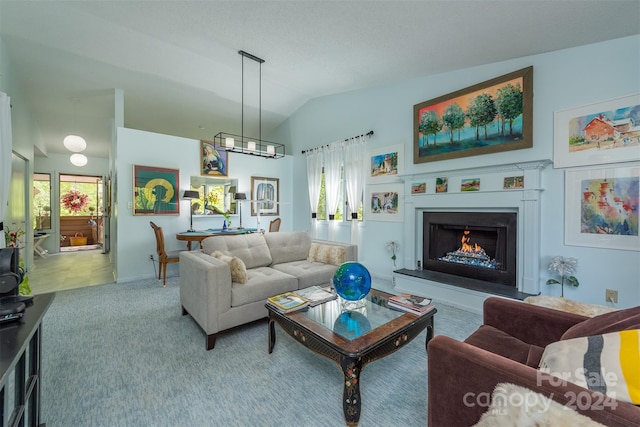 living room with carpet floors, a healthy amount of sunlight, a lit fireplace, and vaulted ceiling