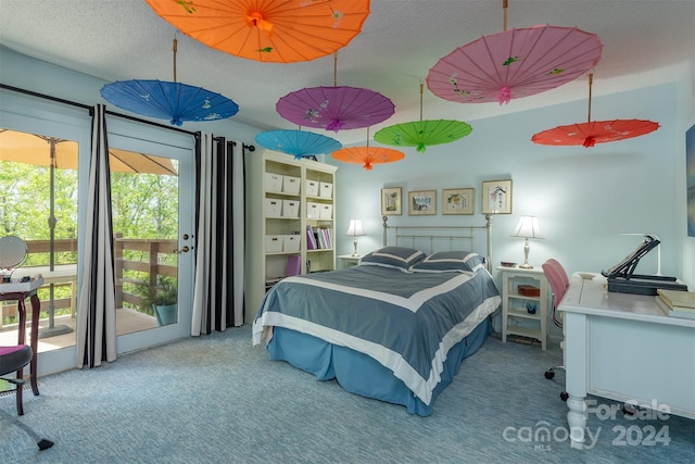 carpeted bedroom with access to exterior and a textured ceiling