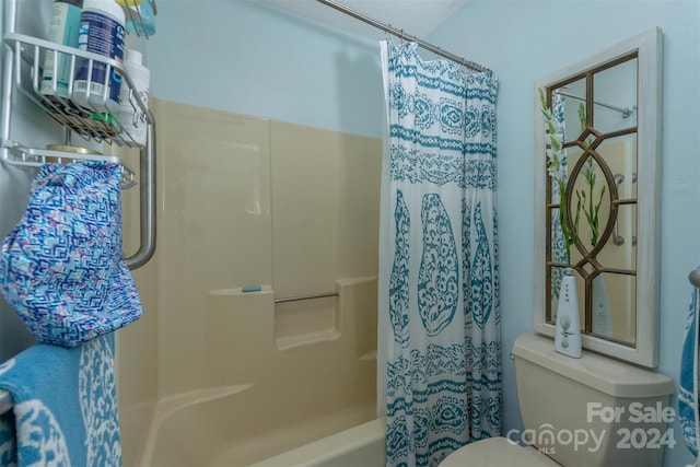 bathroom with toilet and shower / bath combo with shower curtain