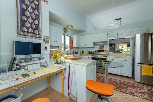 kitchen featuring white cabinets, appliances with stainless steel finishes, a breakfast bar, a peninsula, and light countertops