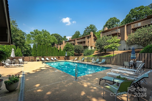 pool featuring fence and a patio