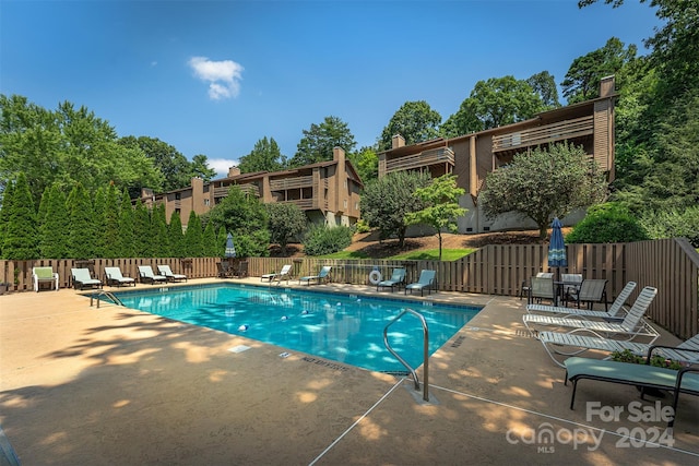 community pool with fence and a patio