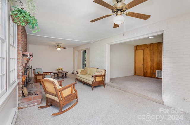 living room featuring brick wall, ceiling fan, and light colored carpet