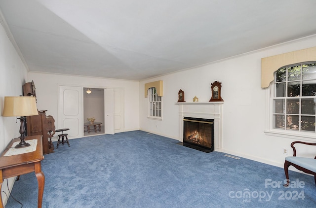 sitting room with plenty of natural light, crown molding, and carpet