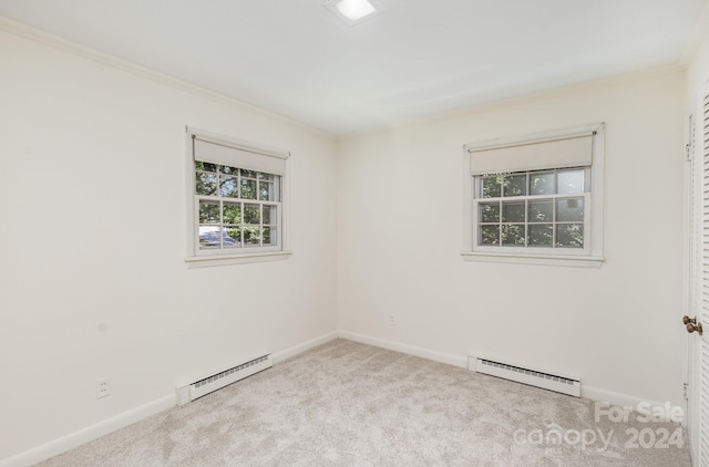 carpeted empty room with a baseboard heating unit and ornamental molding