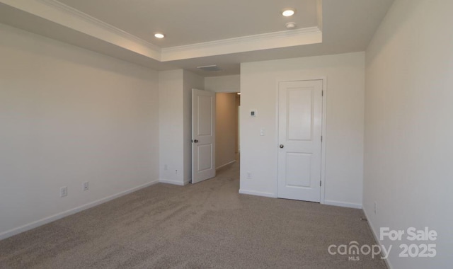 unfurnished bedroom with a raised ceiling, crown molding, and light colored carpet