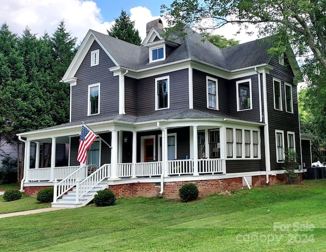 view of front of home with covered porch, cooling unit, and a front yard