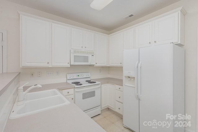 kitchen featuring white cabinetry, sink, and white appliances