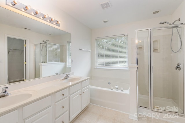 bathroom featuring vanity and independent shower and bath