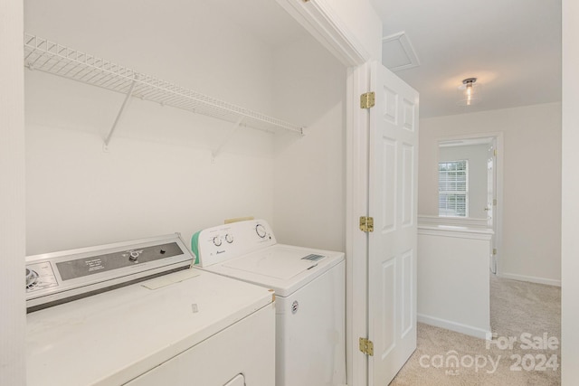 laundry room with washing machine and dryer and light carpet