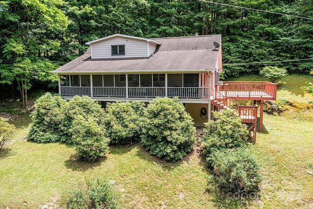 view of front of property featuring a deck, a front lawn, stairway, and a sunroom