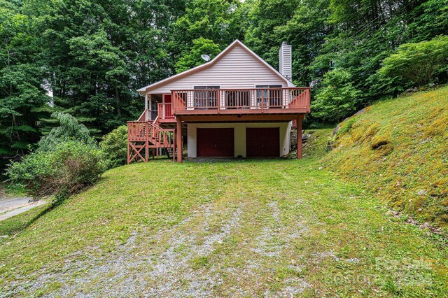 rear view of house with a deck and a lawn