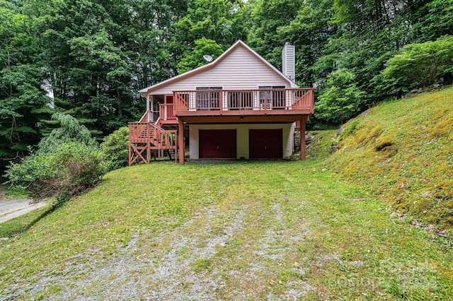 view of front of home with a deck, driveway, stairway, a front yard, and a chimney