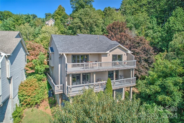 rear view of house featuring a shingled roof