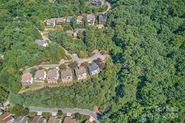 drone / aerial view with a wooded view and a residential view