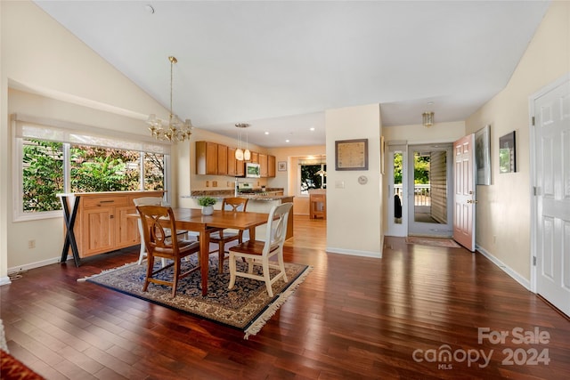 dining room featuring a chandelier, plenty of natural light, dark wood-style floors, and vaulted ceiling