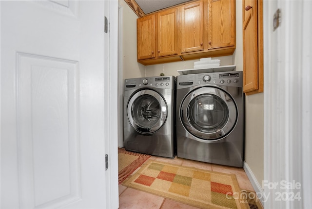 laundry area with cabinet space, baseboards, and washer and clothes dryer