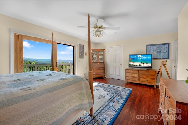 bedroom featuring a mountain view, access to outside, dark wood-style flooring, and ceiling fan