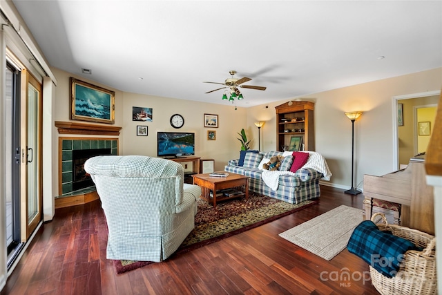 living room with a fireplace, baseboards, a ceiling fan, and wood finished floors