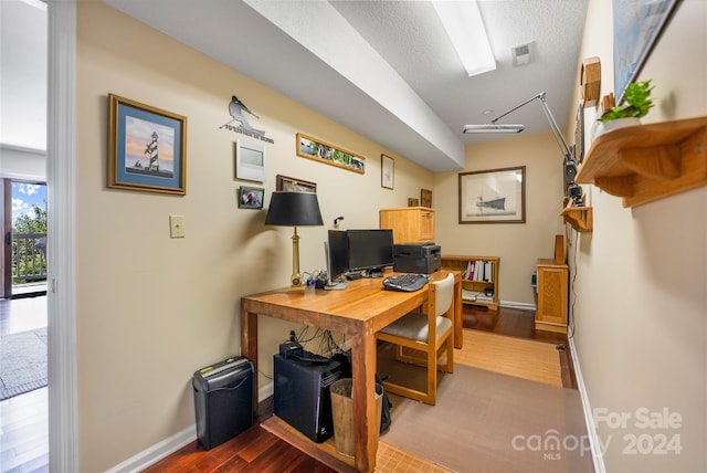 office space with baseboards, a textured ceiling, and wood finished floors