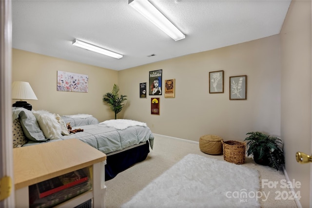 bedroom featuring visible vents, carpet, and a textured ceiling