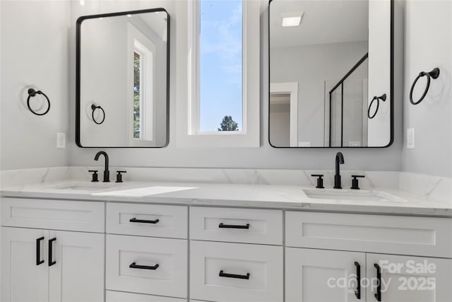 bathroom featuring a shower with door and vanity