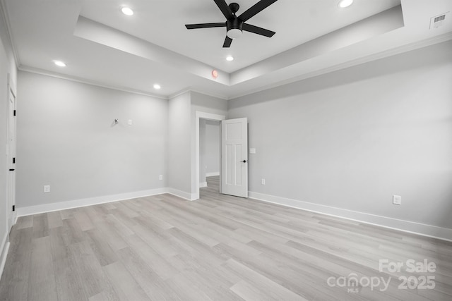 unfurnished room with ceiling fan, ornamental molding, light hardwood / wood-style floors, and a tray ceiling