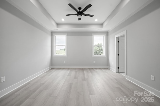 unfurnished room featuring ceiling fan, a raised ceiling, and light hardwood / wood-style floors