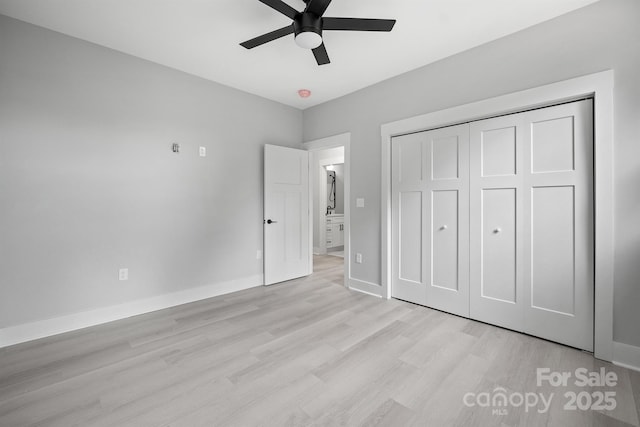 unfurnished bedroom with light hardwood / wood-style flooring, a closet, and ceiling fan