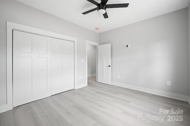 unfurnished bedroom with ceiling fan, light hardwood / wood-style floors, and a closet