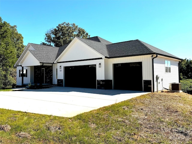 modern farmhouse featuring a garage, cooling unit, concrete driveway, and roof with shingles