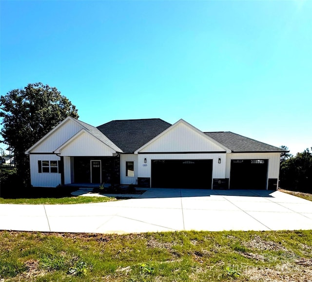 modern farmhouse featuring driveway, a shingled roof, and a garage