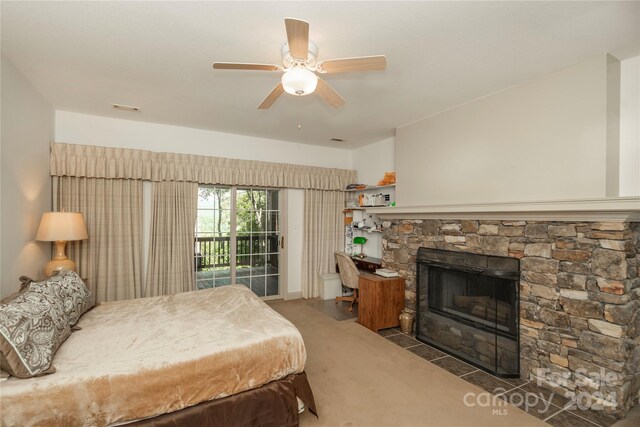 bedroom featuring access to outside, a fireplace, carpet flooring, and ceiling fan