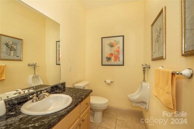 bathroom with toilet, tile patterned floors, and vanity