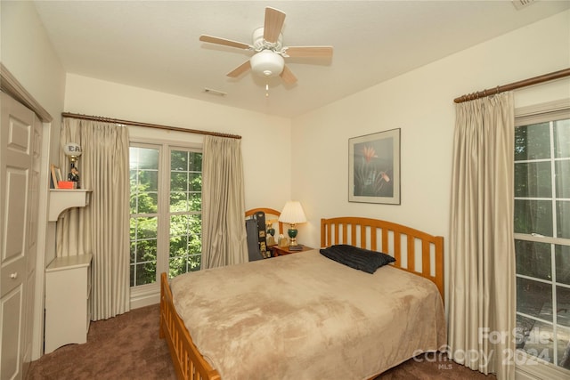 carpeted bedroom featuring ceiling fan and a closet