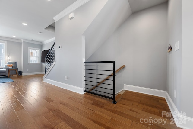 staircase with ornamental molding and hardwood / wood-style floors