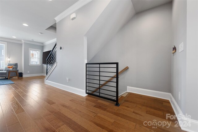 stairs featuring hardwood / wood-style flooring and ornamental molding