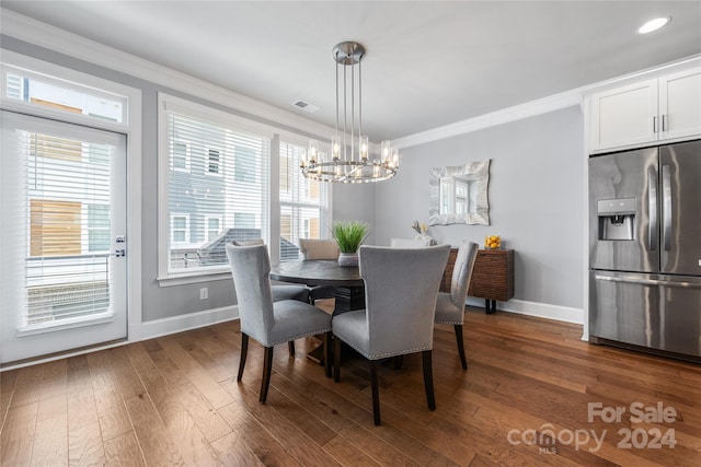 dining area with an inviting chandelier, ornamental molding, and dark hardwood / wood-style floors