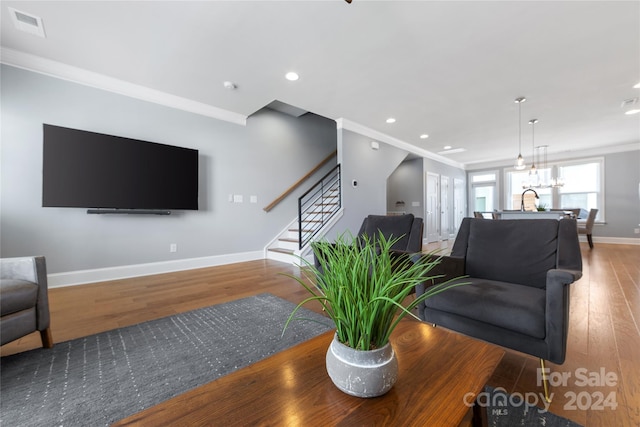 living room with sink, wood-type flooring, and ornamental molding