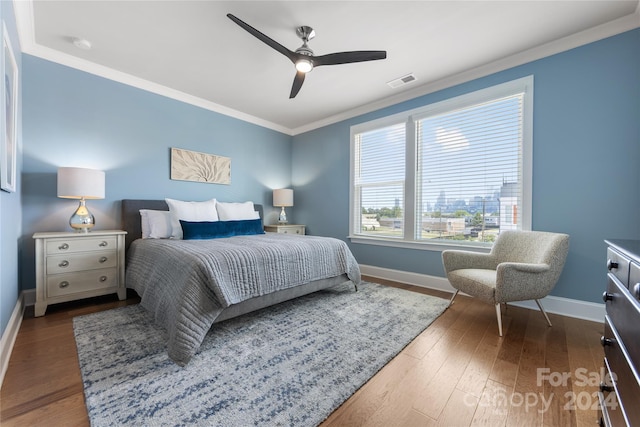 bedroom with ceiling fan, crown molding, and dark hardwood / wood-style flooring