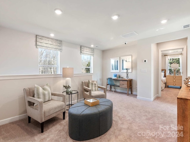 sitting room featuring light carpet, baseboards, and visible vents