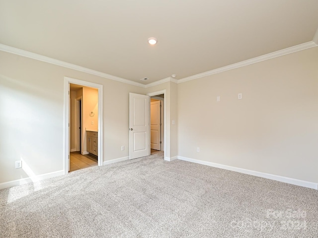 unfurnished bedroom featuring crown molding, baseboards, connected bathroom, and light colored carpet