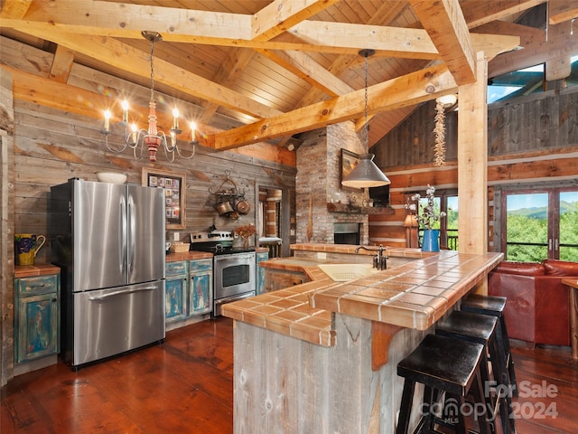 kitchen with fridge, dark hardwood / wood-style flooring, a kitchen bar, tile countertops, and sink