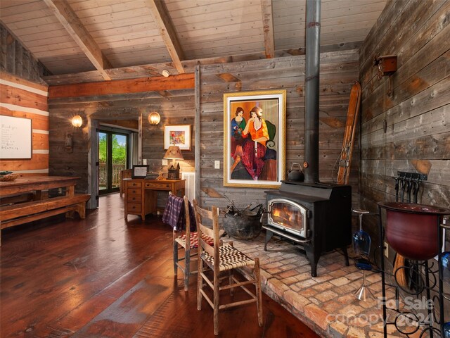 dining space featuring a wood stove, wooden walls, wood ceiling, hardwood / wood-style floors, and lofted ceiling with beams