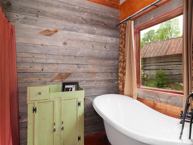 bathroom with wooden walls and a bathtub