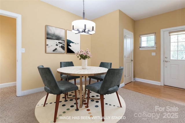 dining space featuring hardwood / wood-style floors and an inviting chandelier