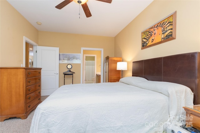 bedroom featuring connected bathroom, light colored carpet, and ceiling fan