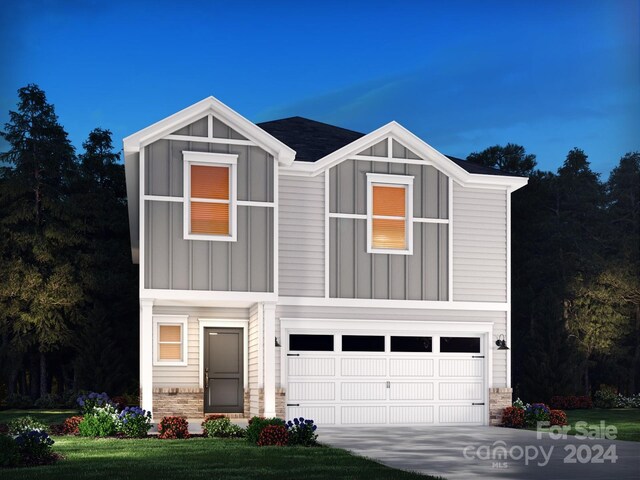 view of front of home with a garage and a front lawn