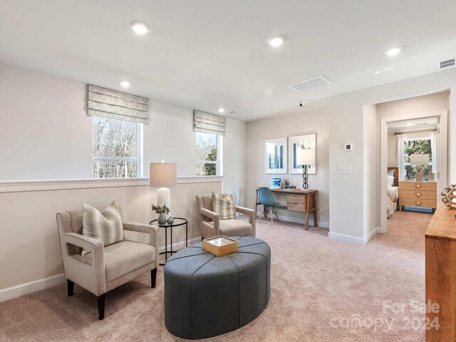 sitting room featuring light colored carpet