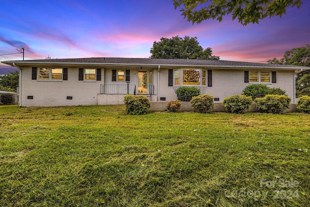 ranch-style home with a lawn